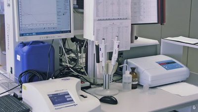Das Foto zeigt einen Schreibtisch in Labor-Umgebung mit Prüfgeräten